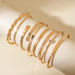 Detailed set of eight gold-plated bracelets featuring diverse textures and star patterns
