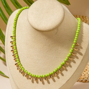 Collier bohème en perles vert herbe avec breloques dorées en forme de gouttelette