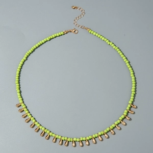 Détail du collier de perles vertes avec pendentifs dorés en goutte et fermoir mousqueton
