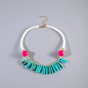 Détail du collier bohème avec perles turquoise en forme de goutte et rose magenta