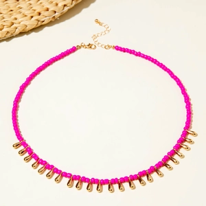 Détail du collier bohème en perles rose fuchsia avec breloques gouttes dorées et fermoir