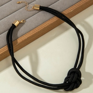 Détail du collier à nœuds en cordon tressé noir avec fermoir en métal doré poli