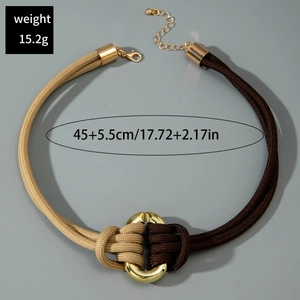 Détail du collier en cordon tressé bicolore avec anneaux dorés entrelacés et 45cm de long