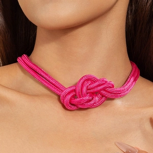 Collier en corde fuchsia à gros nœud avec un pendentif décoratif en forme de cœur stylisé