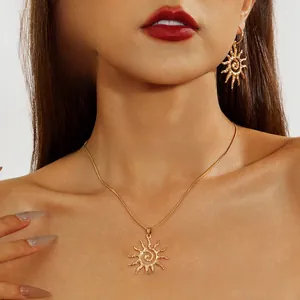 Détail d'un ensemble collier et boucles d'oreilles soleil doré à texture martelée