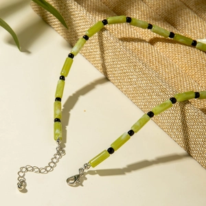 Détail du collier de perles avec cylindres en résine verte et perles noires avec fermoir