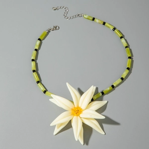 Détail du collier floral avec pendentif fleur en résine blanche et perles tubes vertes