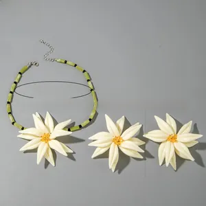 Détail d'un ensemble collier et boucles d'oreilles d'été avec grandes fleurs en résine crème