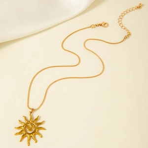 Vue détaillée d'un pendentif soleil doré avec texture spirale sur une chaîne serpent