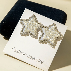 Vue détaillée des boucles d'oreilles étoiles avec perles fantaisie et strass brillants