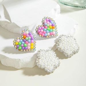 Vue macro de boucles d'oreilles cœur avec perles colorées et détails en strass brillants