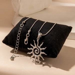 Détail du pendentif soleil évidé avec spirale sur chaîne serpent et fermoir mousqueton