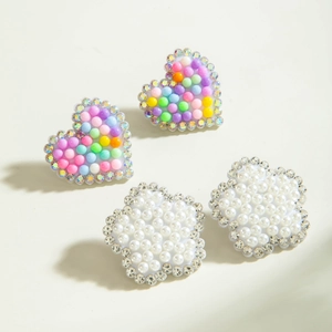 Vue macro de breloques cœur et fleurs avec perles pastel, perles nacrées et strass brillants