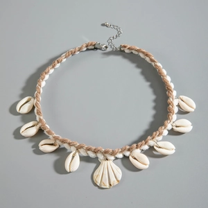 Detail of bohemian woven necklace with natural shells and white cowrie pendants