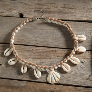 Detail of bohemian beach necklace with handmade cowrie shells and woven cord fastening