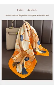 Detail of floral silk scarf with rose patterns and tassels tied on a leather handbag