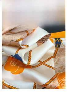 Close-up of silk-satin scarf texture with nautical rope and floral pattern in orange