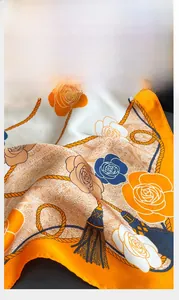Macro shot of orange camellia silk scarf showing refined stitching and fringe details