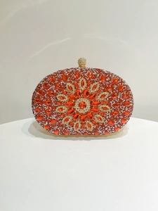 Macro detail of luxury evening clutch bag featuring intricate red and white crystal flower pattern