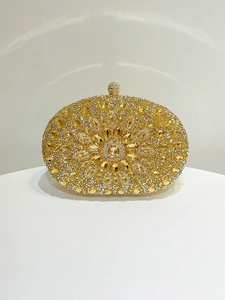 Detail of oval evening clutch with gold rhinestones and sparkling crystal sphere clasp