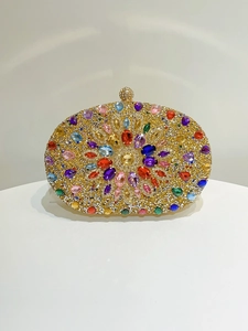 Close-up of golden evening clutch featuring colorful rhinestones and gemstone patterns