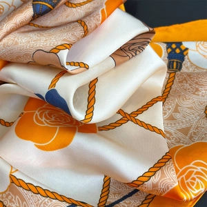 Detail of silk scarf with orange rose floral patterns and nautical rope design