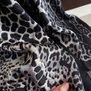 Detail shot of leopard print silk fabric showing smooth texture and neat hemmed edges