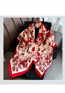 Dettaglio di sciarpa in seta con farfalle su borsa nera con bordi floreali rossi vivaci