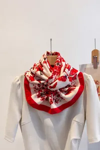 Dettaglio della stampa a fragole su foulard in raso crema con bordi rossi