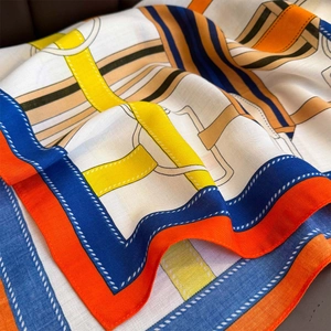 Close-up of silk scarf showing twill texture and equestrian patterns in vibrant colors