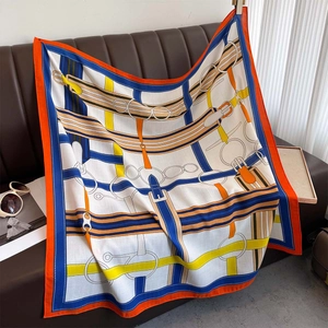 Silk scarf with equestrian print on leather sofa with luxury lifestyle accessories