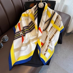 Detail of luxury silk scarf with equestrian belt print and royal blue rolled edges