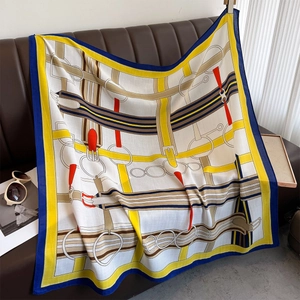 Detail of silk scarf with equestrian horse bit pattern draped on a leather chair