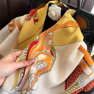 Detailed view of luxury horse bridle pattern on silk scarf with herringbone weave texture