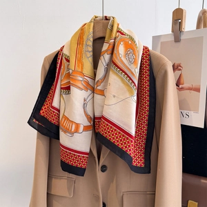 Silk-textured horse pattern scarf draped on camel blazer for luxury spring fashion style