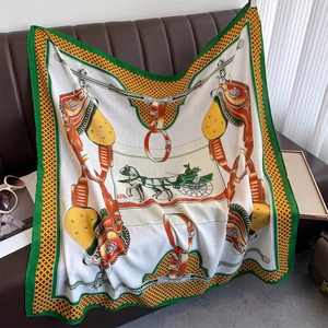 Detail of silk-like square scarf featuring horse bridle prints and elegant green borders