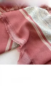 Detail of ethnic geometric print on retro pink shawl with soft fringed edges