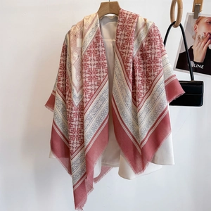 Ethnic retro pink square shawl with geometric patterns draped on a white blazer