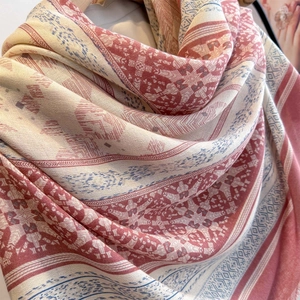 Close-up of ethnic print shawl showing smooth silk texture and red geometric patterns