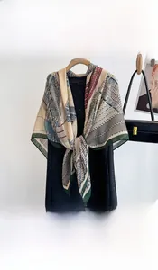 Detailed pattern of vintage floral scarf on a wooden hanger with smooth silk texture