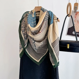Retro green and beige cotton-linen feel shawl with geometric patterns on a wooden hanger