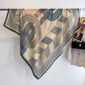 Beige cotton-linen square scarf with navy and burgundy rope pattern hanging on a rack