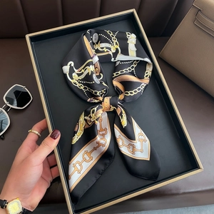 Élégant foulard en soie noir avec motif chaîne dorée noué en nœud dans une boîte cadeau