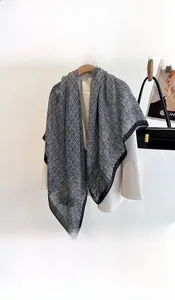 Detail of 130cm grey geometric printed silk scarf hanging on a wooden hanger