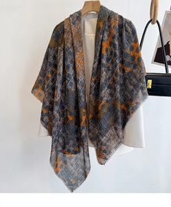 Detail of grey cotton linen scarf with orange floral patterns and fringed edges
