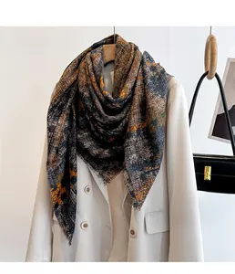 Detail of printed large square scarf with fringes draped over an off-white blazer