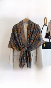 Detail of printed cotton linen scarf with geometric floral pattern on white blazer