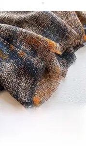 Detailed view of ethnic print scarf with frayed tassel edges and woven texture