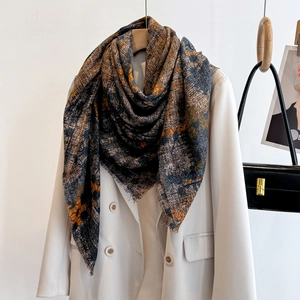Artistic orange and grey printed linen-feel shawl draped over a beige blazer