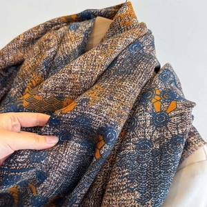 Detail of soft vintage jacquard scarf with wave patterns and frayed edges